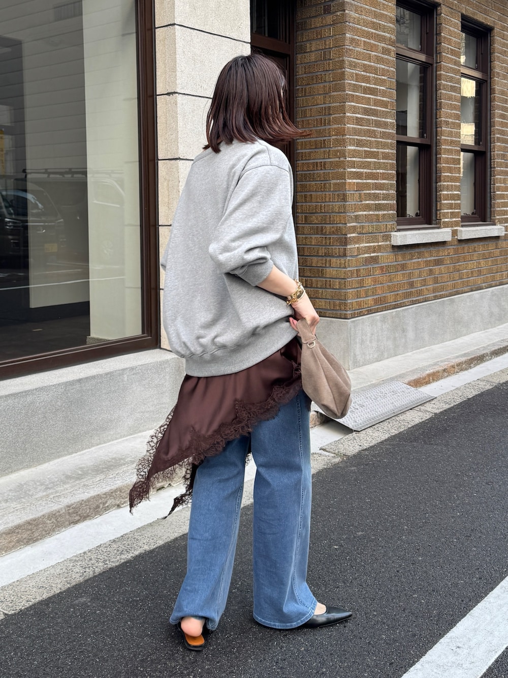 グレー系のTシャツ/カットソー、ブラウン系のキャミソール、ブルー系のデニムパンツを着用したレディースの冬コーディネートの7枚目の写真