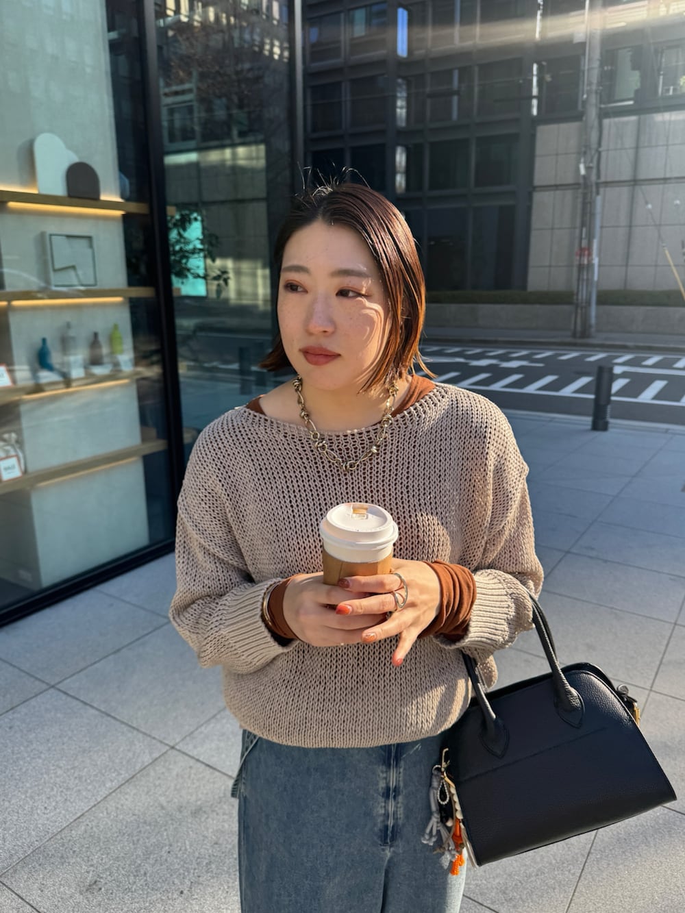ベージュ系のニット/セーター、ブルー系のデニムパンツ、ブラウン系のTシャツ/カットソーを着用したレディースの冬コーディネートの5枚目の写真