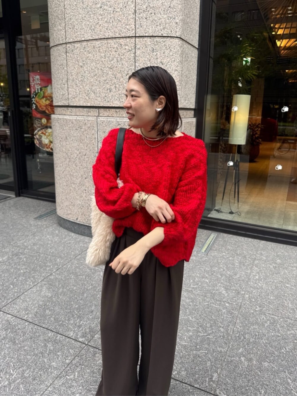 ブラウン系のスラックス、ホワイト系のショルダーバッグ、レッド系のニット/セーターを着用したレディースの秋コーディネートの5枚目の写真