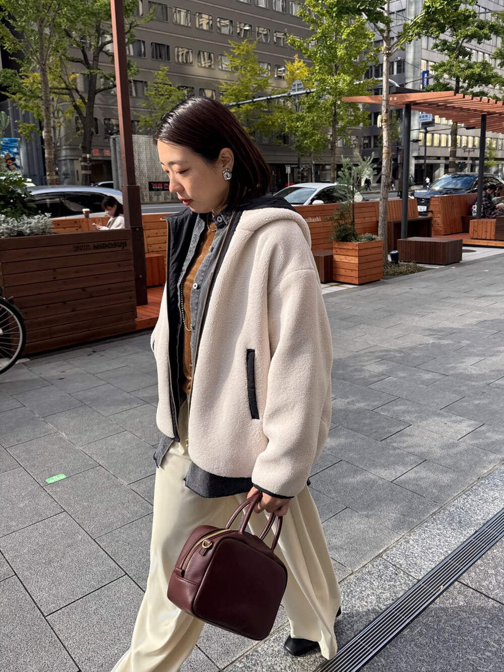 ホワイト系のその他アウター、ブルー系のシャツ/ブラウス、ブラウン系のTシャツ/カットソーを着用したレディースの秋コーディネートの5枚目の写真