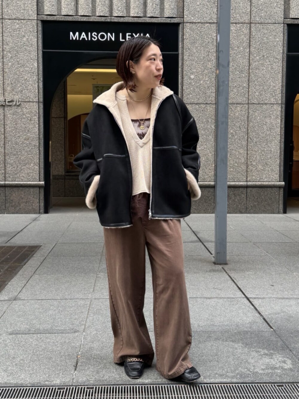 ブラック系のショルダーバッグ、ブラウン系のシャツ/ブラウス、ブラウン系のデニムパンツを着用したレディースの秋コーディネートの4枚目の写真