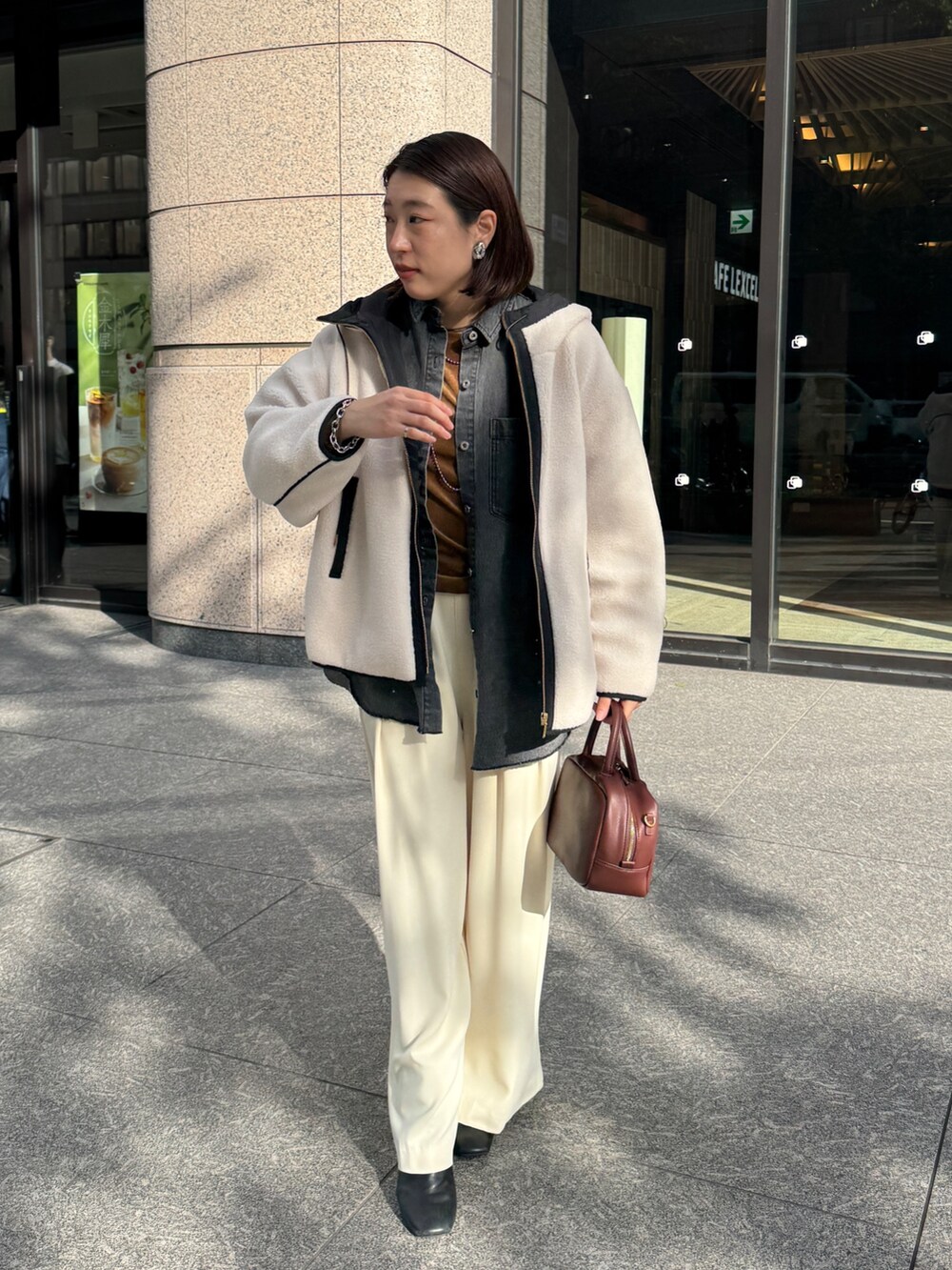 ホワイト系のその他アウター、ブルー系のシャツ/ブラウス、ブラウン系のTシャツ/カットソーを着用したレディースの秋コーディネートの2枚目の写真