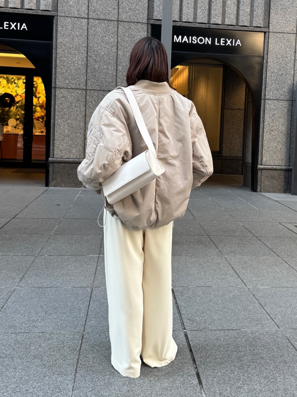 イエロー系のスラックス、ベージュ系のMA-1、ブラウン系のニット/セーターを着用したレディースの秋コーディネートの4枚目の写真