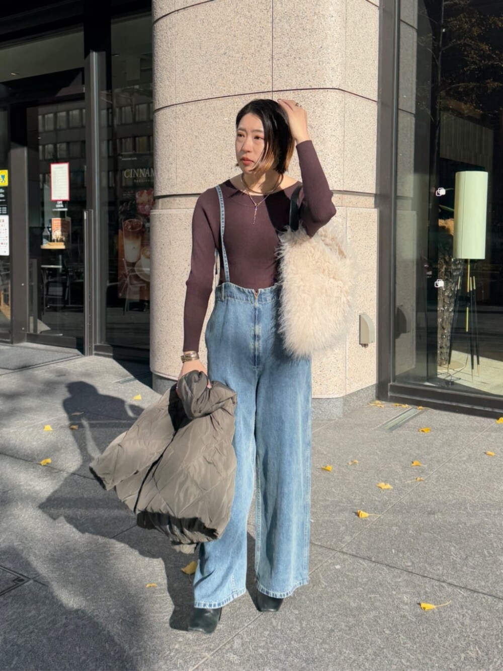 ホワイト系のショルダーバッグ、ブルー系のデニムパンツ、グレー系のその他アウターを着用したレディースの冬コーディネートの5枚目の写真