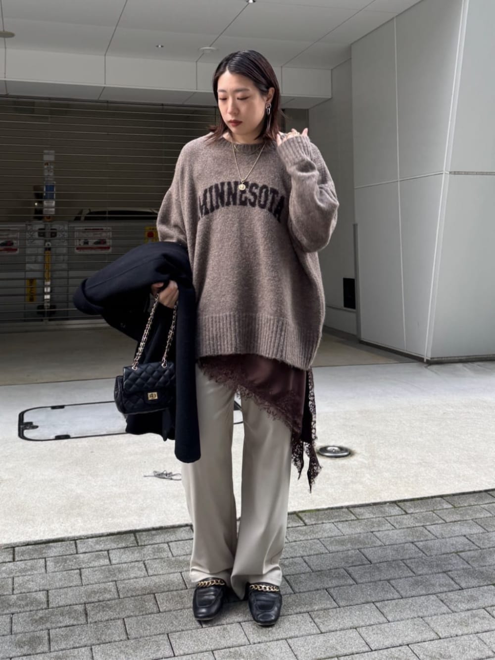 ブラック系のショルダーバッグ、ベージュ系のニット/セーター、ブラウン系のキャミソールを着用したレディースの秋コーディネートの5枚目の写真