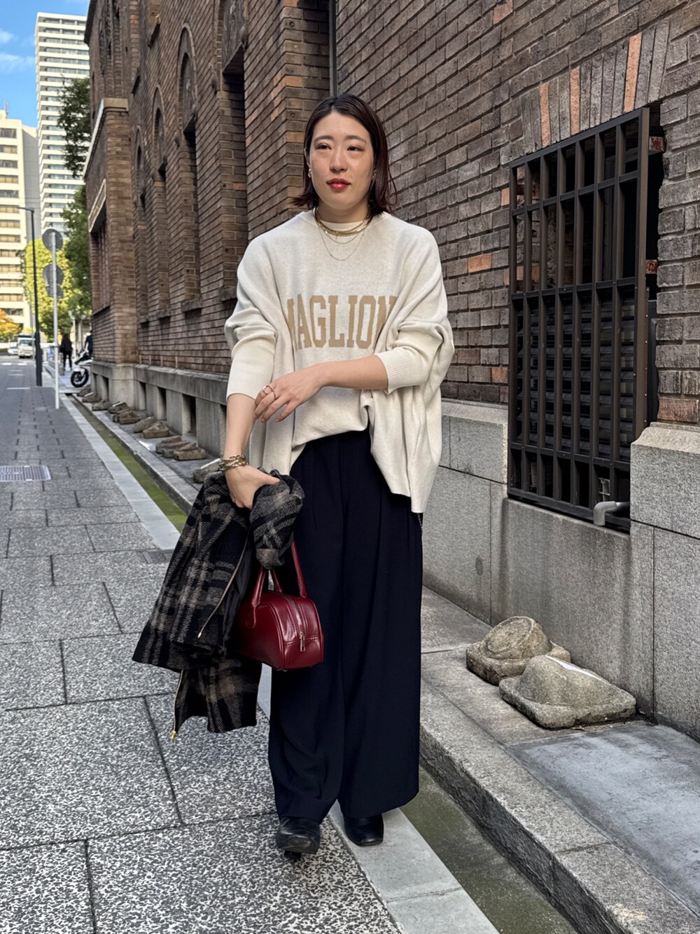 ブルー系のスラックス、ホワイト系のニット/セーター、レッド系のショルダーバッグを着用したレディースの秋コーディネートの7枚目の写真