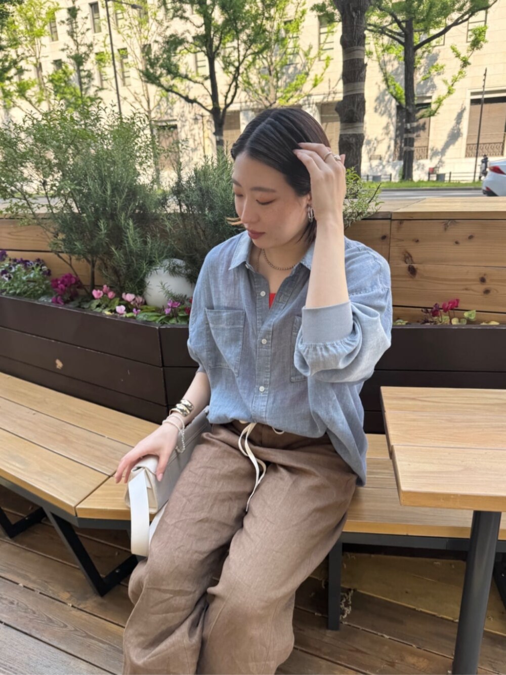 ホワイト系のショルダーバッグ、ブルー系のシャツ/ブラウス、オレンジ系のタンクトップを着用したレディースの春コーディネートの2枚目の写真