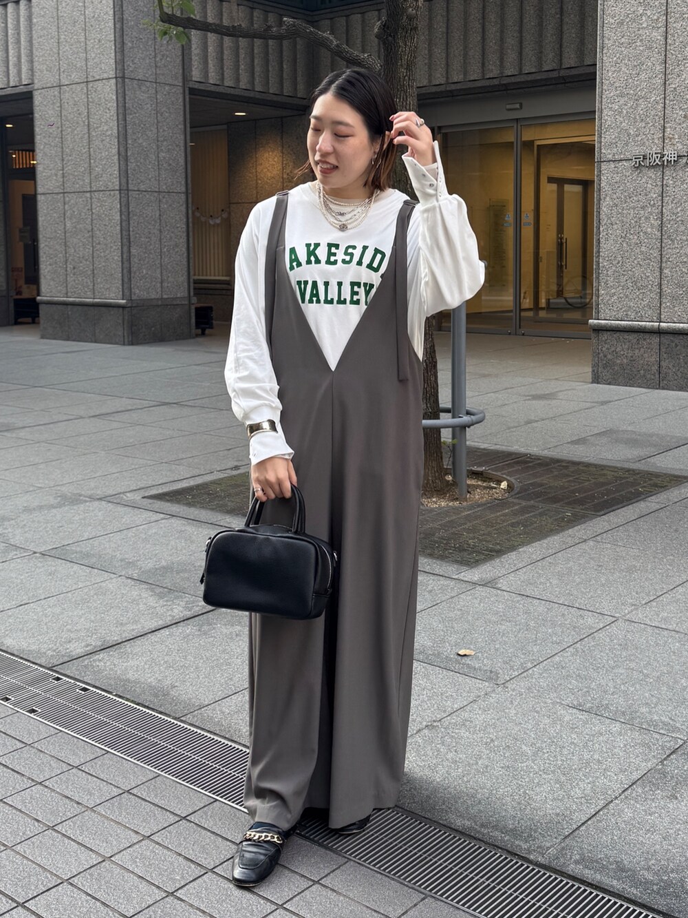 グレー系のつなぎ/オールインワン、ホワイト系のTシャツ/カットソー、シルバー系のネックレスを着用したレディースの冬コーディネートの4枚目の写真