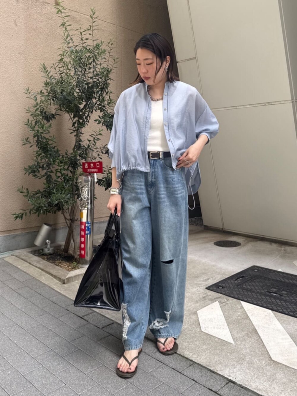 ホワイト系のタンクトップ、ブラック系のショルダーバッグ、ブルー系のデニムパンツを着用したレディースの春コーディネートの3枚目の写真