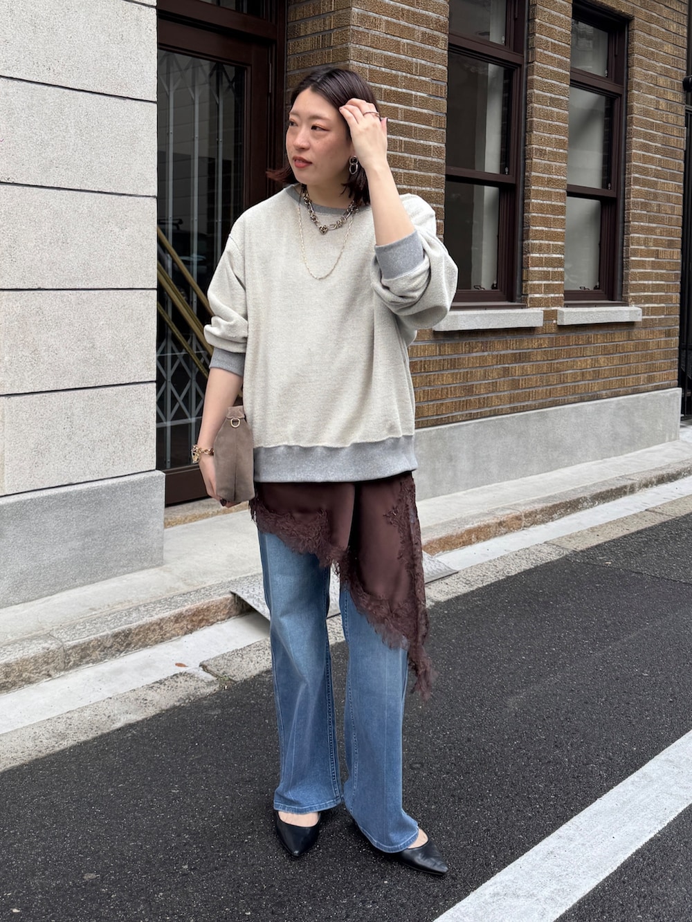 グレー系のTシャツ/カットソー、ブラウン系のキャミソール、ブルー系のデニムパンツを着用したレディースの冬コーディネートの2枚目の写真