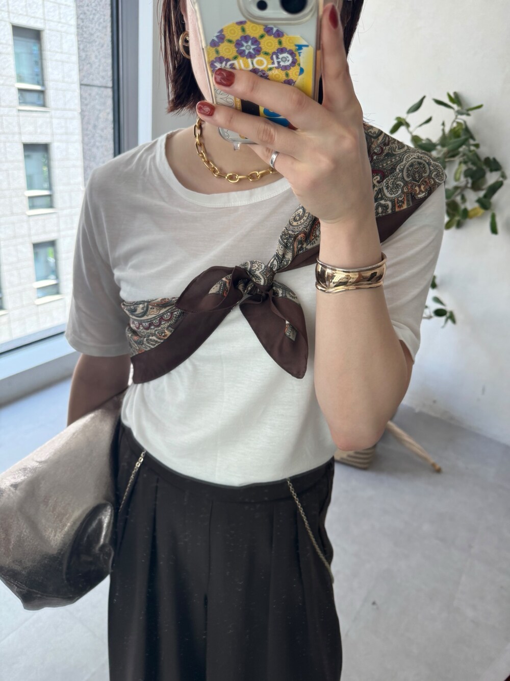 ホワイト系のTシャツ/カットソー、ブラウン系のスラックス、ブラウン系のストール/ショールを着用したレディースの夏コーディネートの4枚目の写真