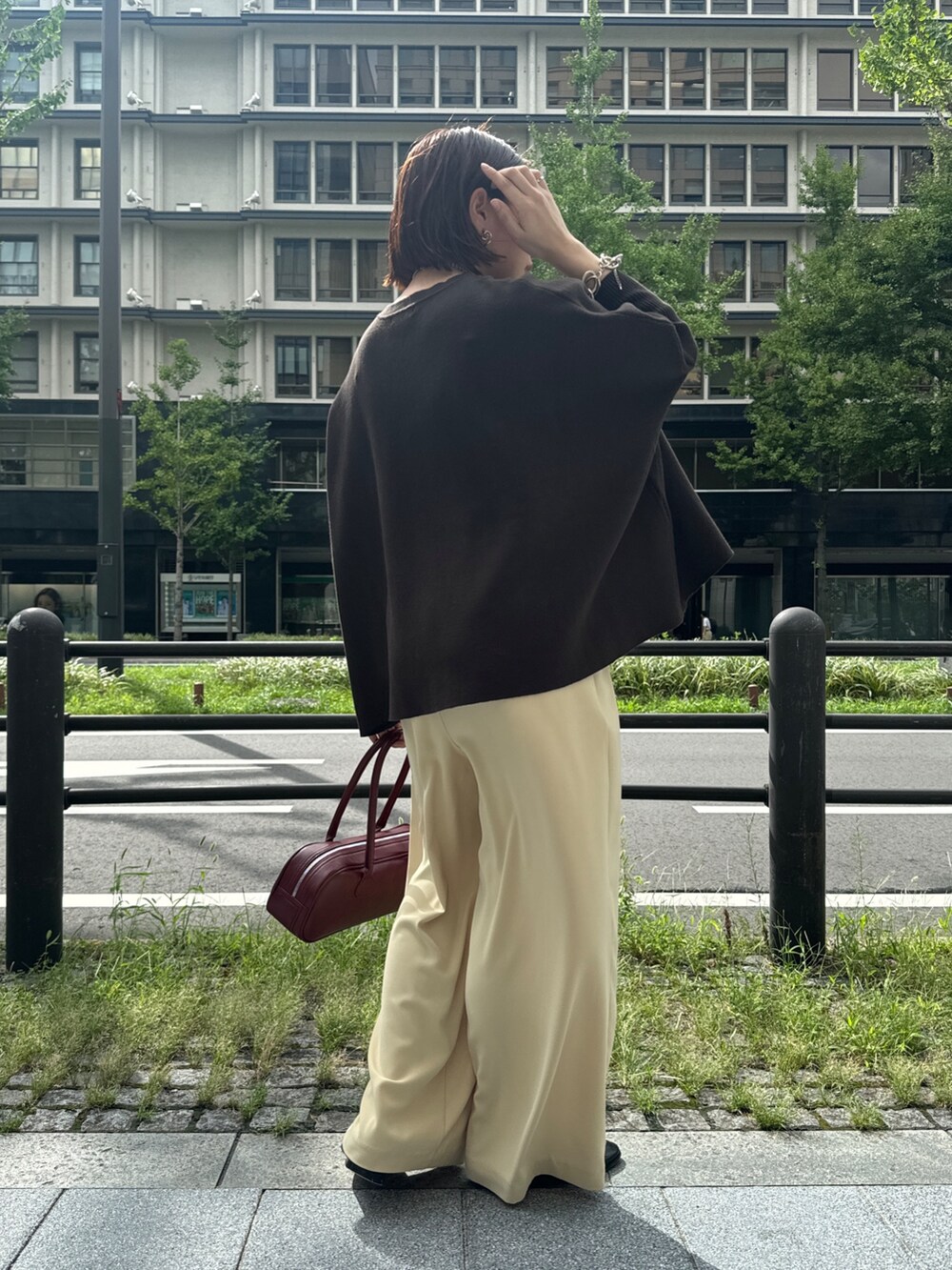 イエロー系のスラックス、ブラウン系のニット/セーター、ゴールド系のネックレスを着用したレディースの秋コーディネートの6枚目の写真