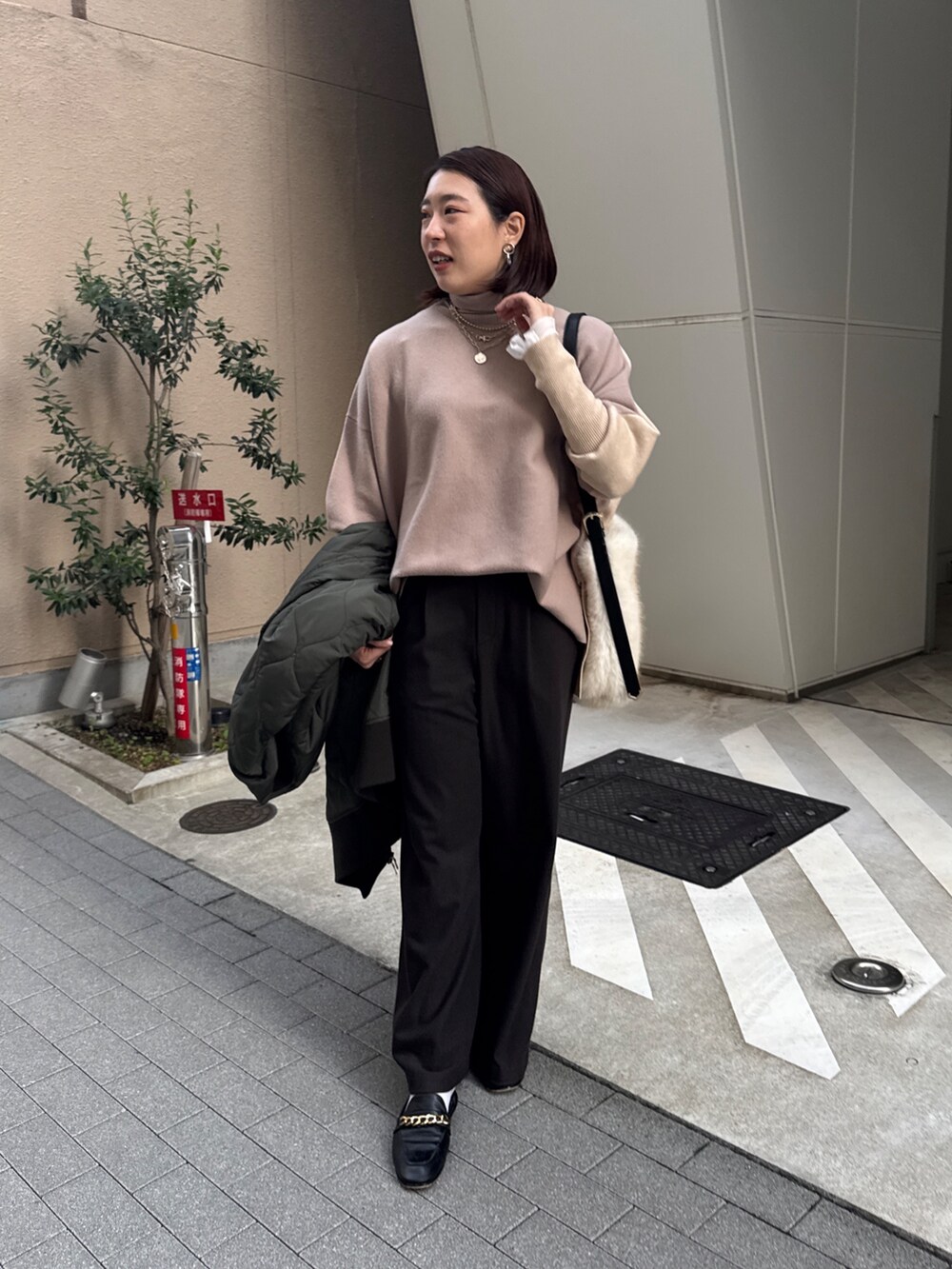 グリーン系のその他アウター、ベージュ系のニット/セーター、ブラウン系のその他パンツを着用したレディースの冬コーディネートの6枚目の写真