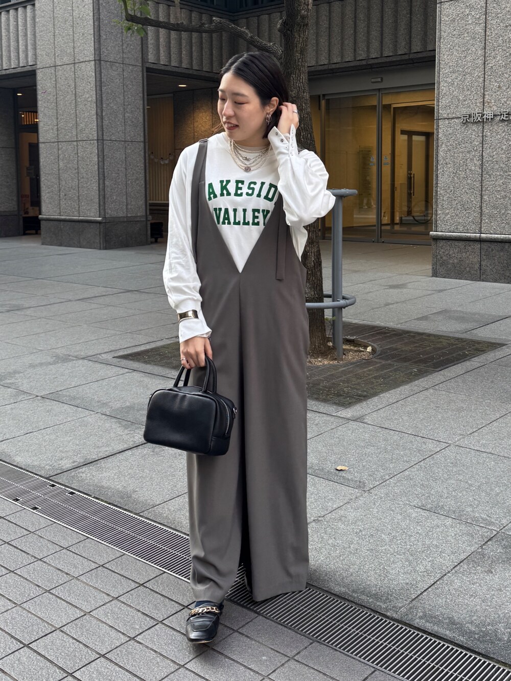 グレー系のつなぎ/オールインワン、ホワイト系のTシャツ/カットソー、シルバー系のネックレスを着用したレディースの冬コーディネートの3枚目の写真