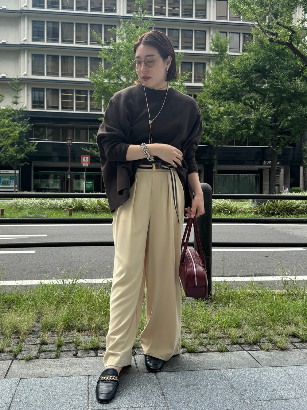 イエロー系のスラックス、ブラウン系のニット/セーター、ゴールド系のネックレスを着用したレディースの秋コーディネートの3枚目の写真