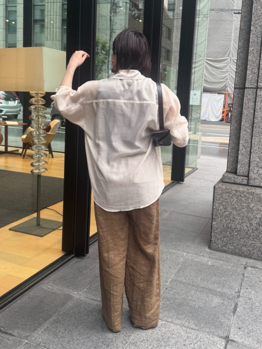 ブラウン系のショルダーバッグ、ブラウン系のTシャツ/カットソー、ベージュ系のシャツ/ブラウスを着用したレディースの夏コーディネートの3枚目の写真