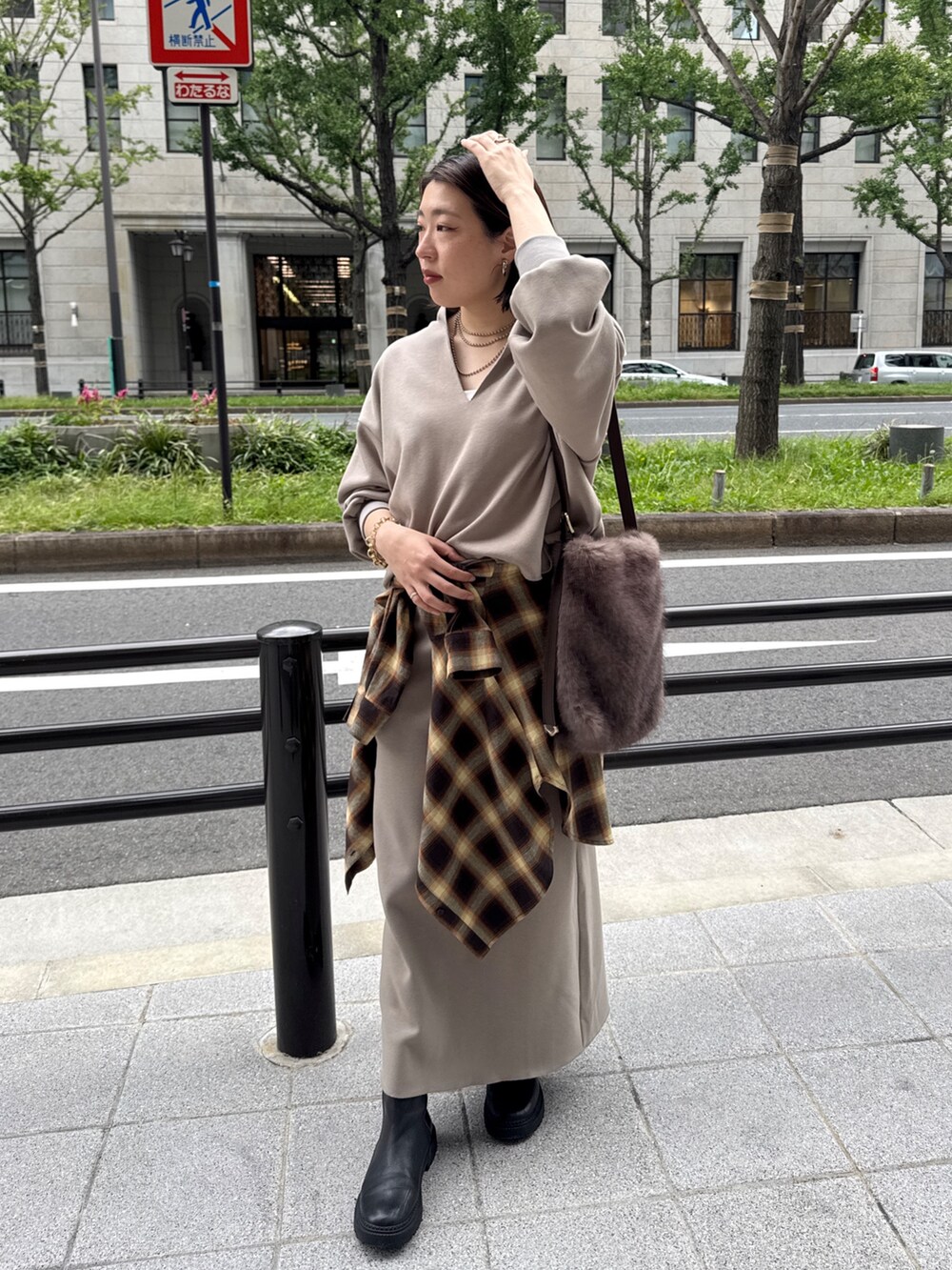 ベージュ系のTシャツ/カットソー、ベージュ系のスカート、ブラウン系のショルダーバッグを着用したレディースの秋コーディネートの7枚目の写真