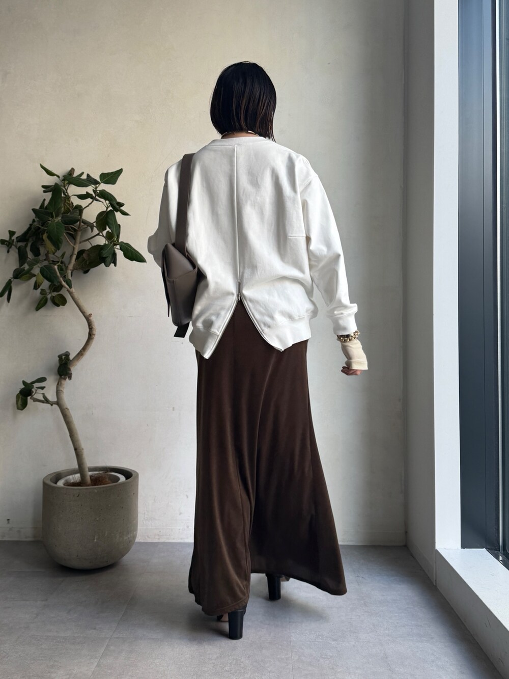 ベージュ系のその他アウター、ブラウン系のスカート、ホワイト系のTシャツ/カットソーを着用したレディースの冬コーディネートの6枚目の写真