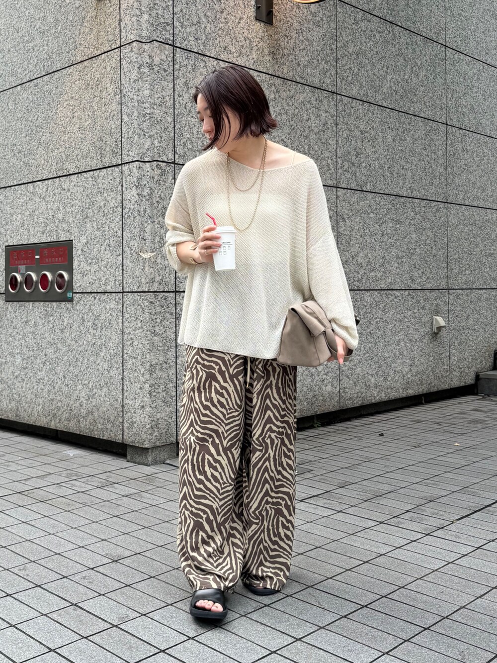 ベージュ系のニット/セーター、ブラウン系のその他パンツを着用したレディースの夏コーディネートの6枚目の写真