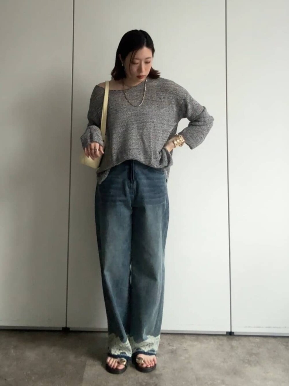 ブラック系のニット/セーター、イエロー系のショルダーバッグ、ブルー系のデニムパンツを着用したレディースの夏コーディネートの5枚目の写真