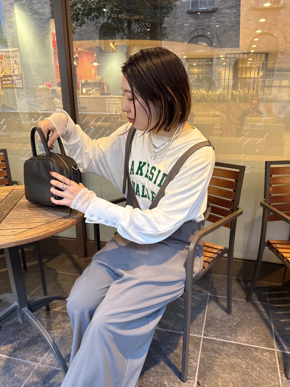 グレー系のつなぎ/オールインワン、ホワイト系のTシャツ/カットソー、シルバー系のネックレスを着用したレディースの冬コーディネートの9枚目の写真