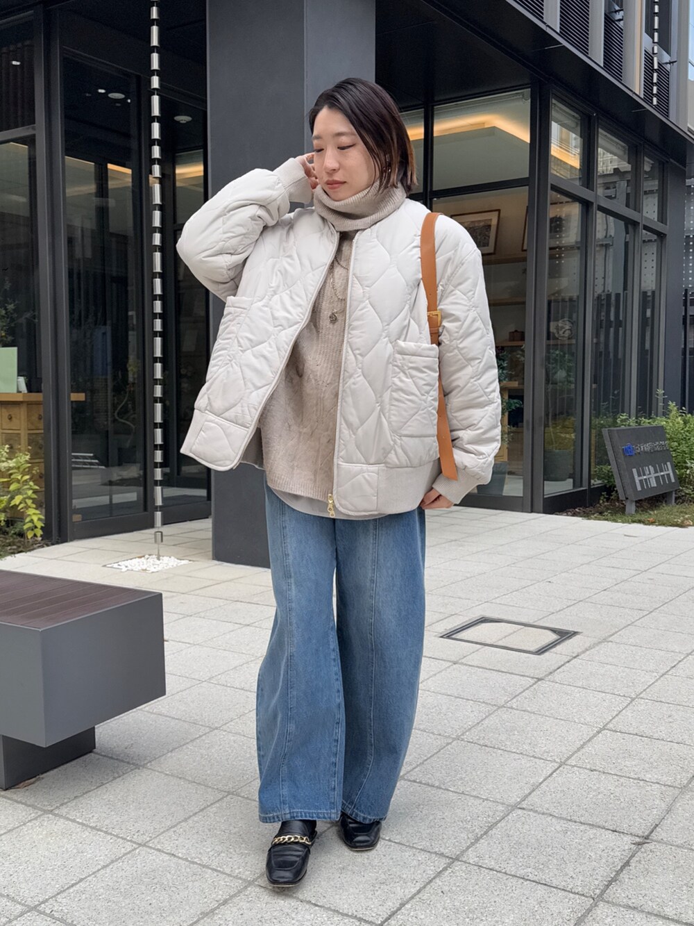 ホワイト系のその他アウター、ベージュ系のニット/セーター、ブルー系のデニムパンツを着用したレディースの冬コーディネートの2枚目の写真