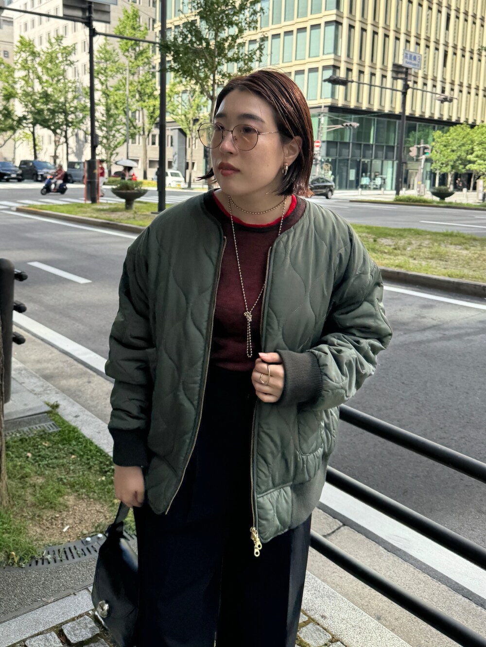 ブラック系のその他パンツ、グリーン系のその他アウター、レッド系のニット/セーターを着用したレディースの秋コーディネートの3枚目の写真