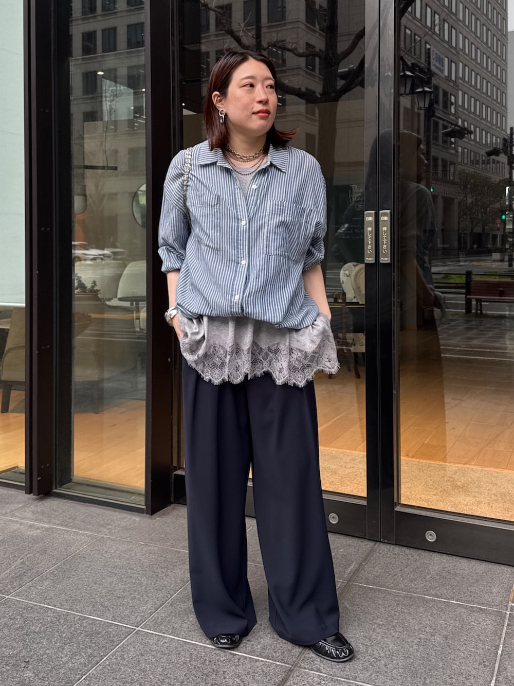 グレー系のTシャツ/カットソー、ブルー系のシャツ/ブラウス、ブルー系のスラックスを着用したレディースの春コーディネートの2枚目の写真