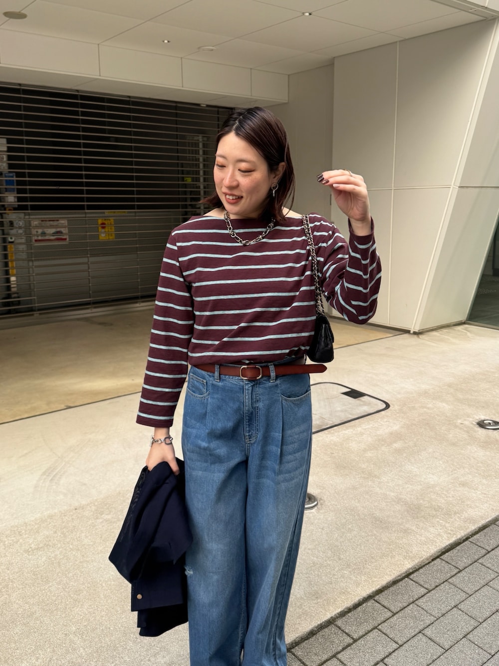 ブルー系のデニムパンツ、ブルー系のテーラードジャケット、ブラウン系のTシャツ/カットソーを着用したレディースの春コーディネートの6枚目の写真