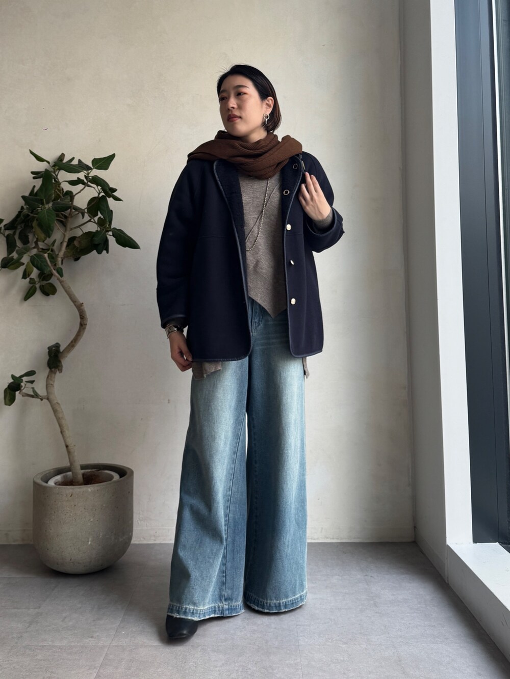 ブルー系のその他アウター、ブルー系のデニムパンツ、グリーン系のニット/セーターを着用したレディースの秋コーディネートの4枚目の写真