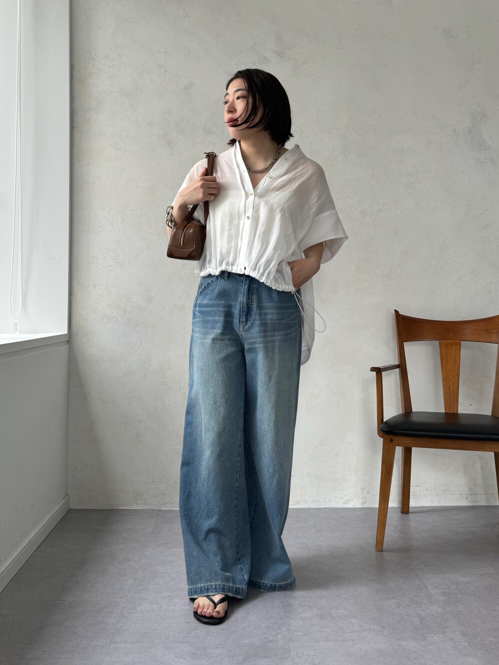 ブルー系のデニムパンツ、ホワイト系のシャツ/ブラウスを着用したレディースの夏コーディネートの2枚目の写真