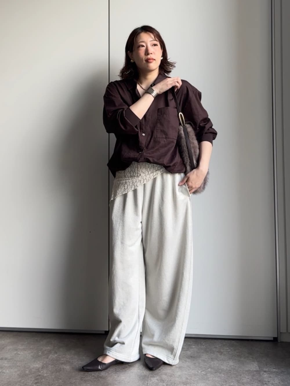 ブラウン系のシャツ/ブラウス、ホワイト系のスウェットパンツ、ブラウン系のトートバッグを着用したレディースの秋コーディネートの3枚目の写真