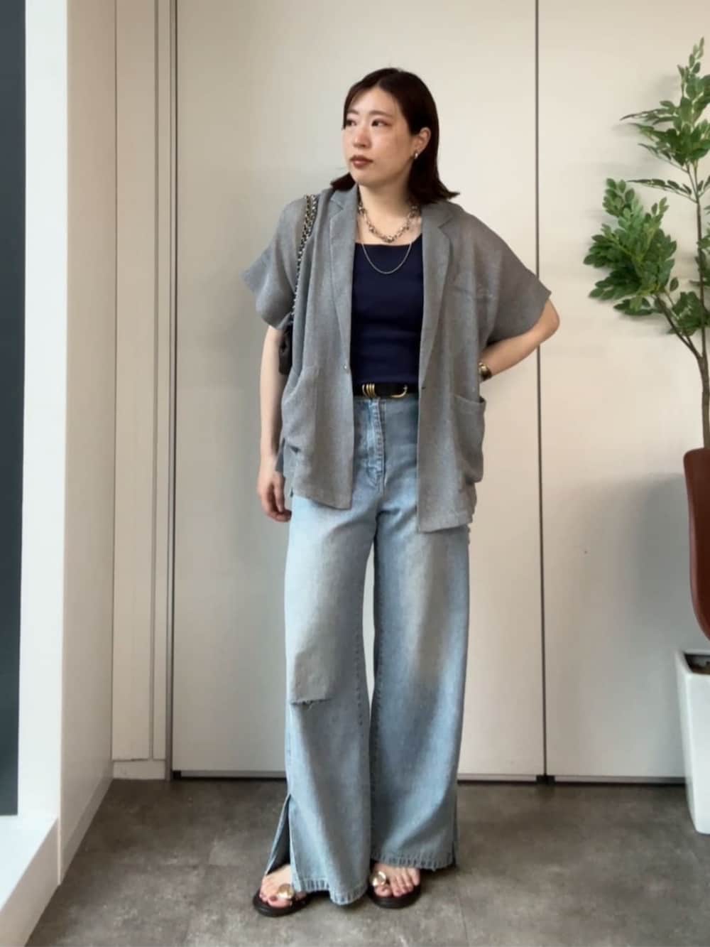 ブルー系のタンクトップ、ブルー系のデニムパンツ、ブラウン系のサンダルを着用したレディースの夏コーディネートの2枚目の写真