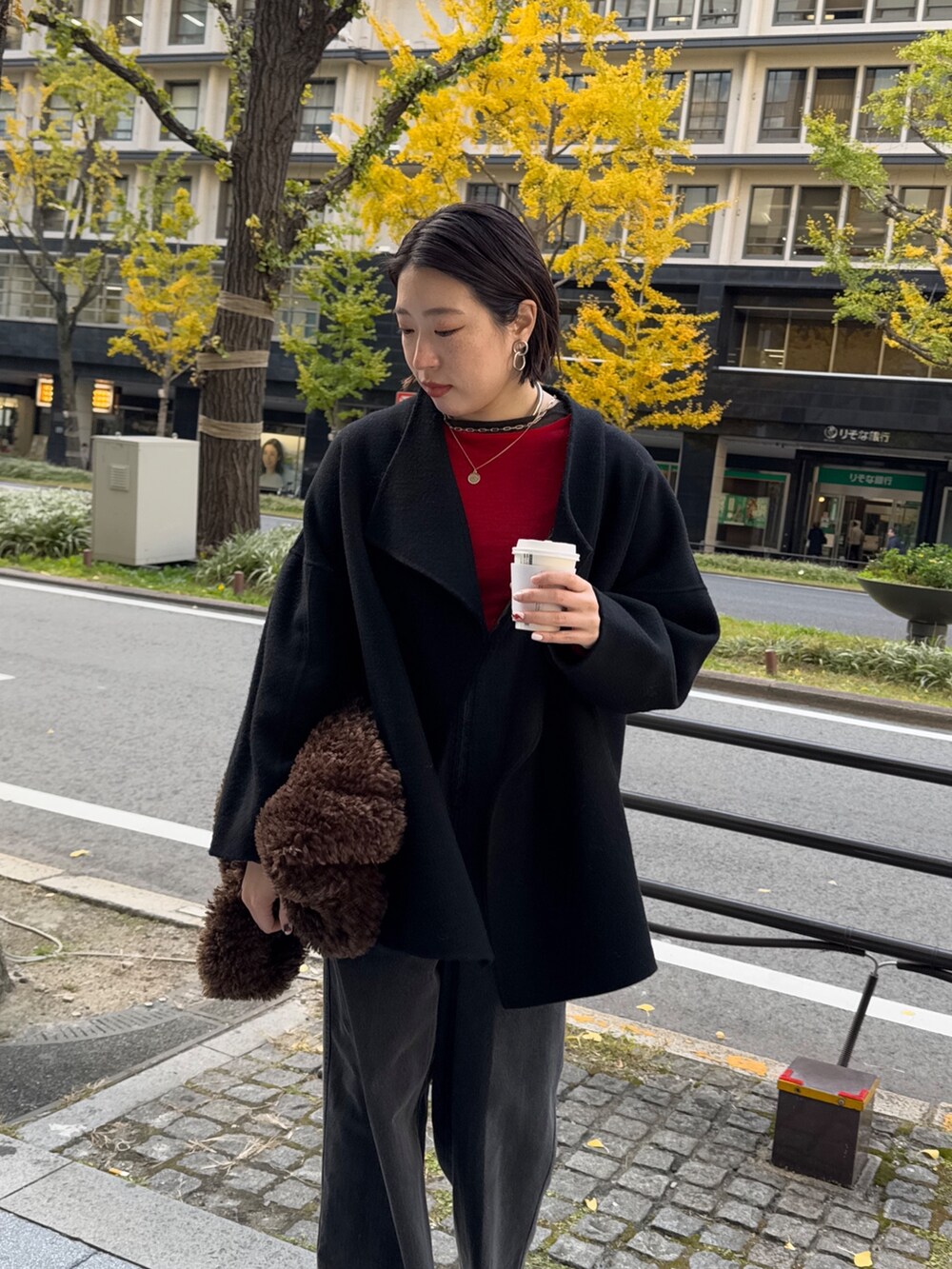 ブラック系のつなぎ/オールインワン、レッド系のニット/セーター、ブラック系のその他アウターを着用したレディースの冬コーディネートの5枚目の写真