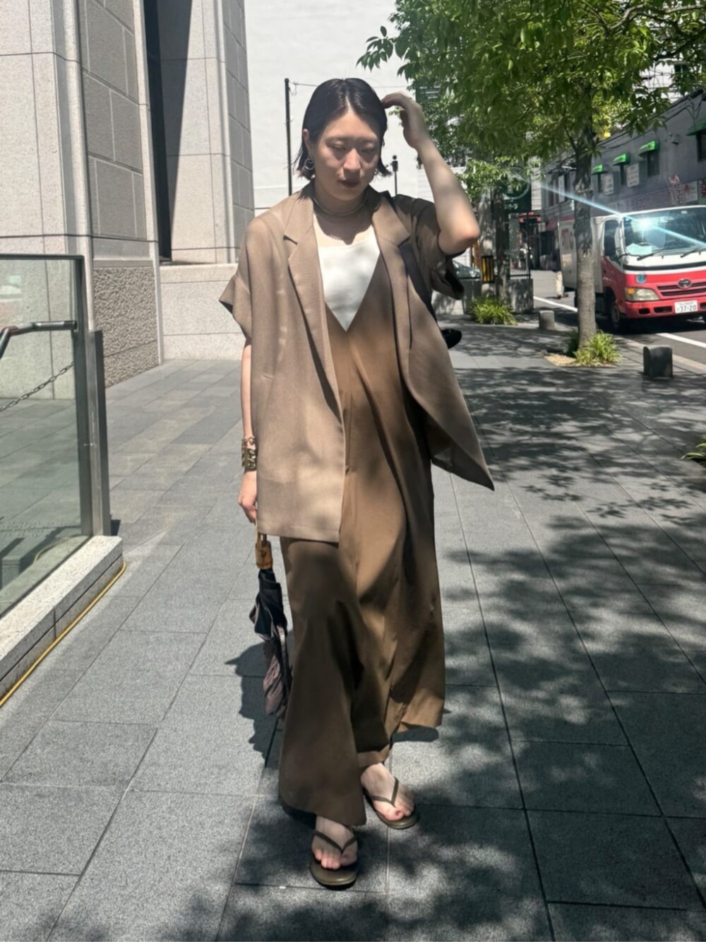 ホワイト系のタンクトップ、ブラウン系のテーラードジャケット、ベージュ系のワンピースを着用したレディースの夏コーディネートの8枚目の写真