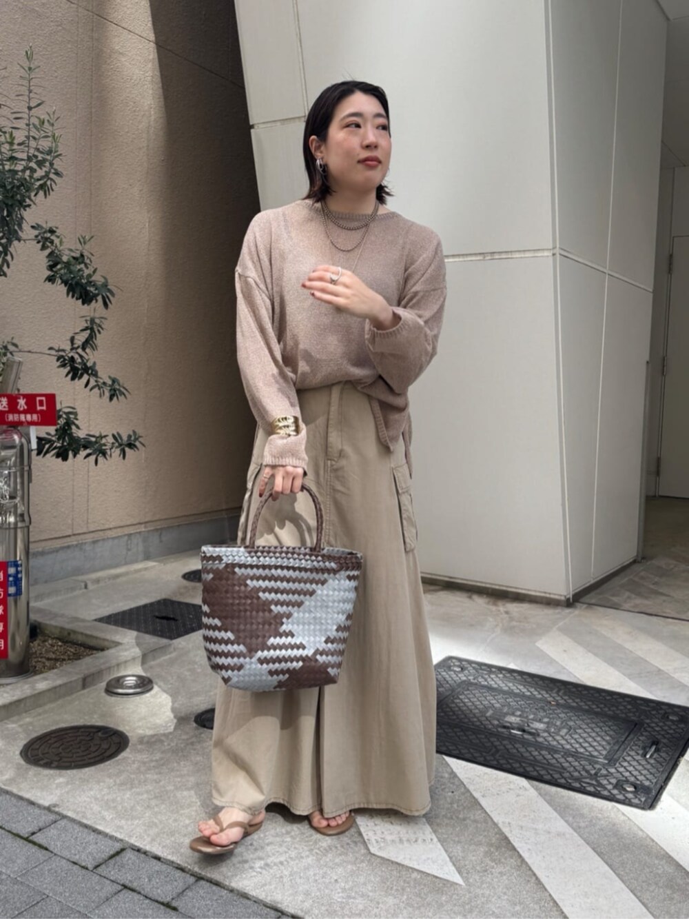 ベージュ系のスカート、ゴールド系のネックレスを着用したレディースの春コーディネートの3枚目の写真