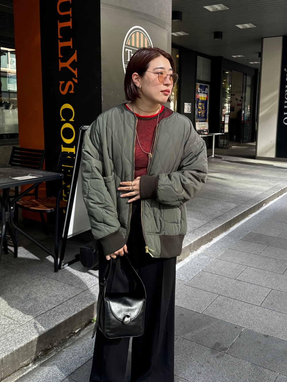 ブラック系のその他パンツ、グリーン系のその他アウター、レッド系のニット/セーターを着用したレディースの秋コーディネートの5枚目の写真