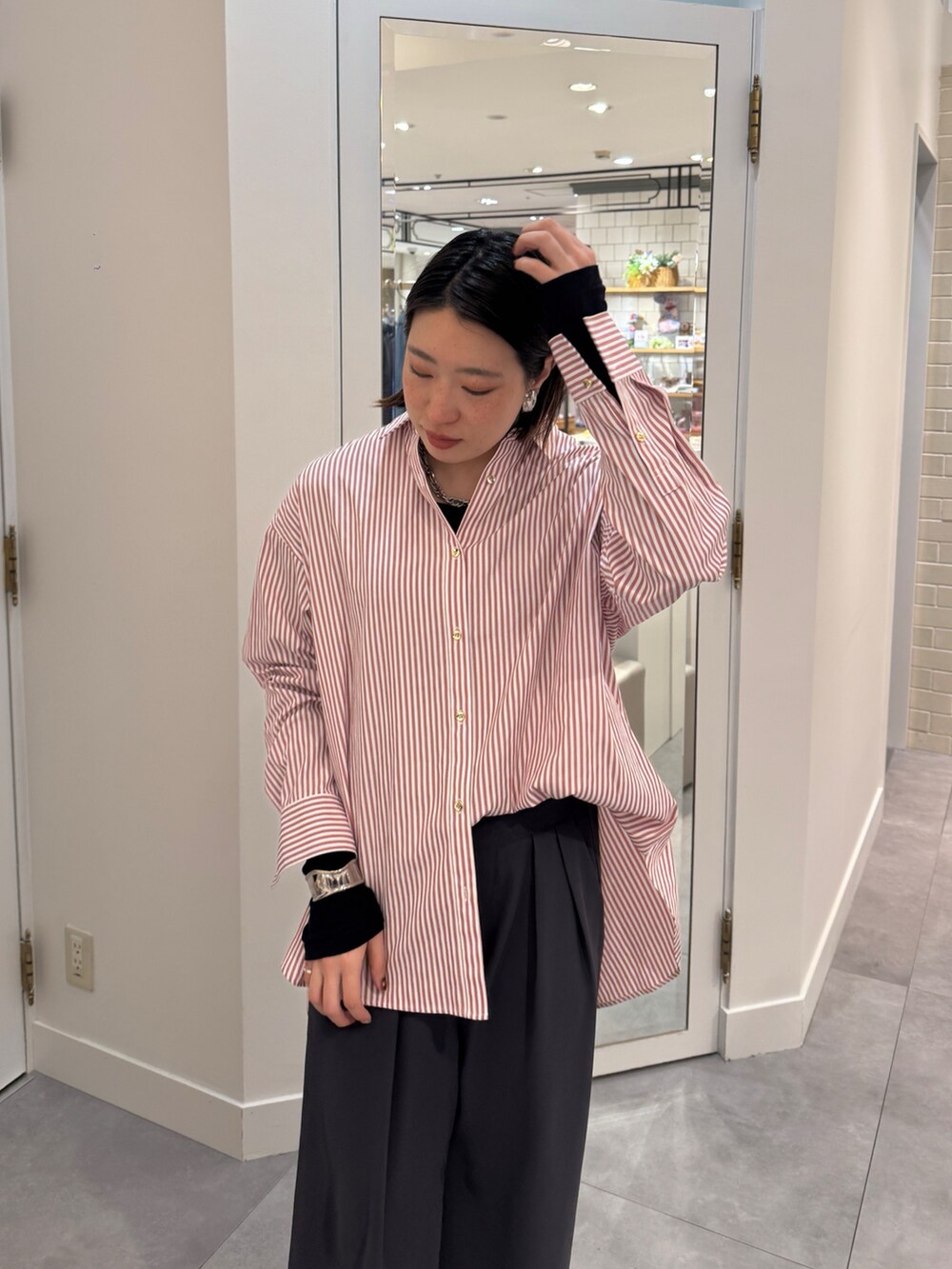 ブラウン系のスラックス、レッド系のシャツ/ブラウス、ブルー系のTシャツ/カットソーを着用したレディースの春コーディネートの7枚目の写真