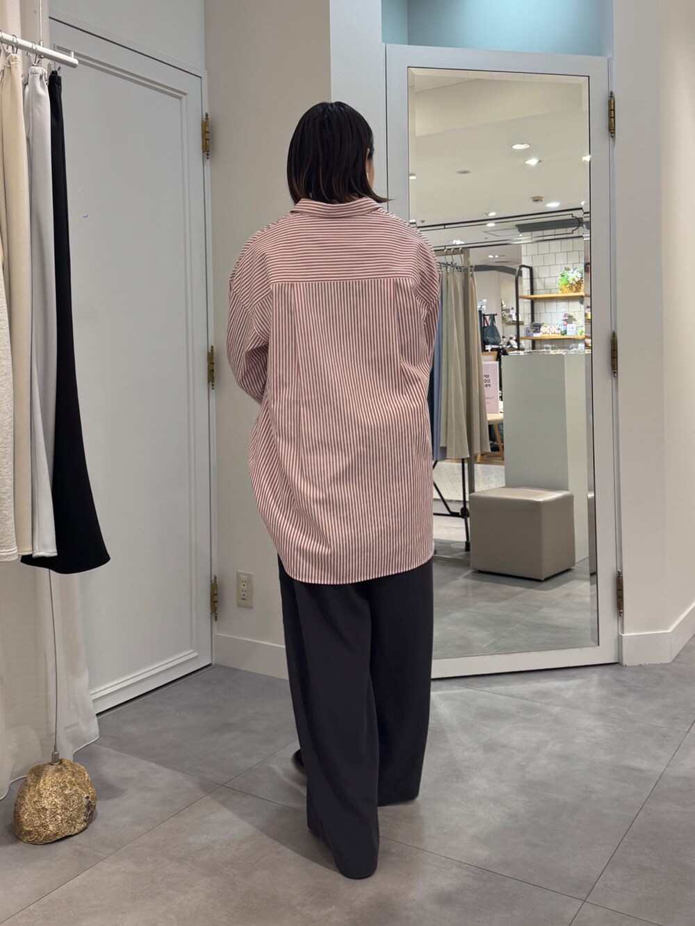 ブラウン系のスラックス、レッド系のシャツ/ブラウス、ブルー系のTシャツ/カットソーを着用したレディースの春コーディネートの4枚目の写真