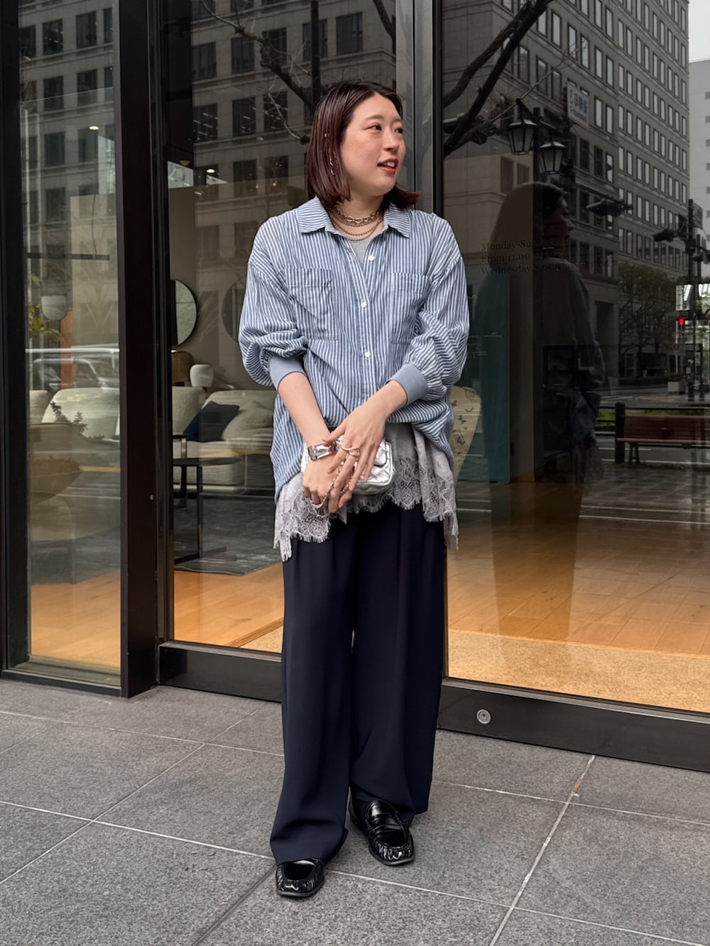 グレー系のTシャツ/カットソー、ブルー系のシャツ/ブラウス、ブルー系のスラックスを着用したレディースの春コーディネートの6枚目の写真