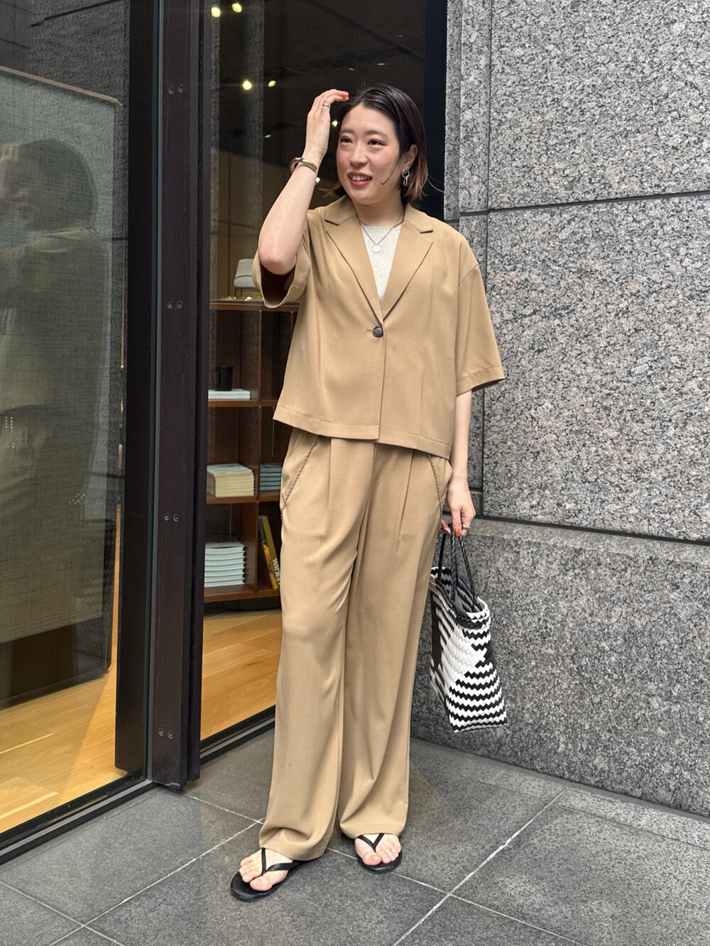 ベージュ系のニット/セーター、ベージュ系のその他パンツ、ベージュ系のテーラードジャケットを着用したレディースの春コーディネートの8枚目の写真