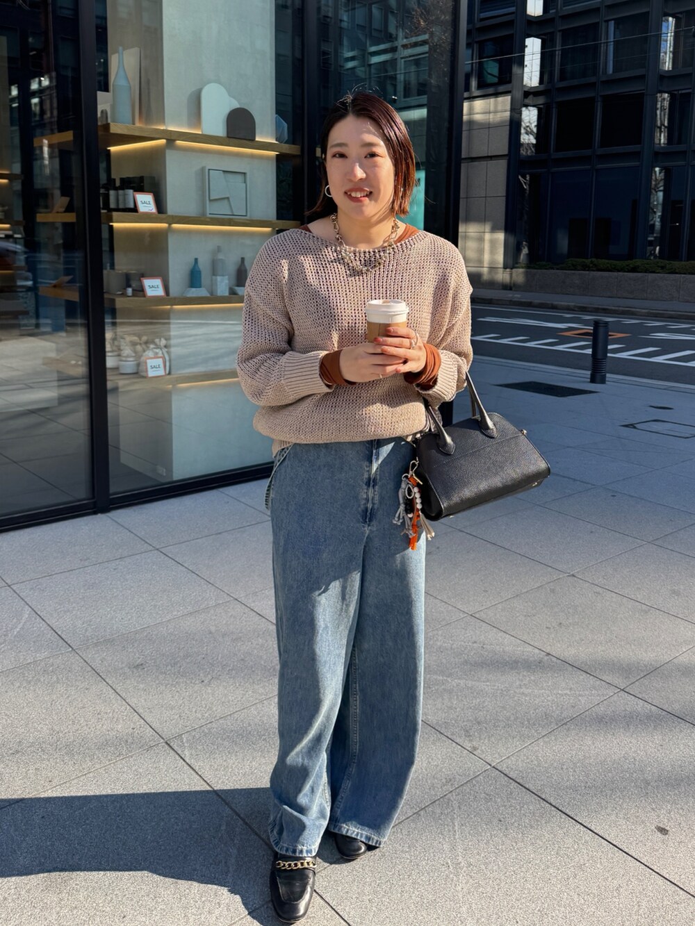 ベージュ系のニット/セーター、ブルー系のデニムパンツ、ブラウン系のTシャツ/カットソーを着用したレディースの冬コーディネートの7枚目の写真