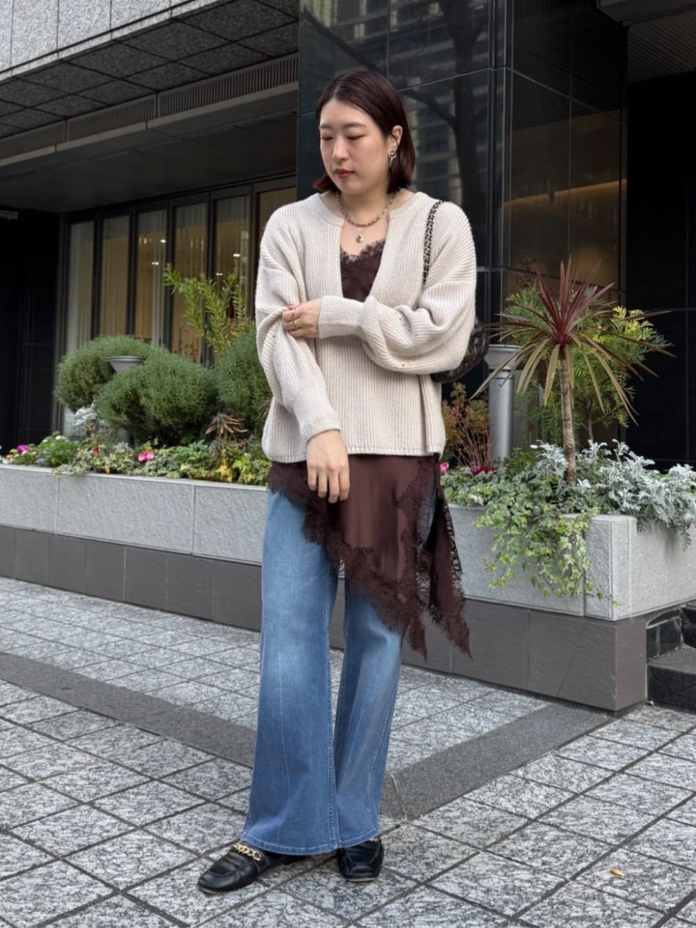 ブラウン系のキャミソール、ブルー系のデニムパンツ、ホワイト系のニット/セーターを着用したレディースの冬コーディネートの6枚目の写真