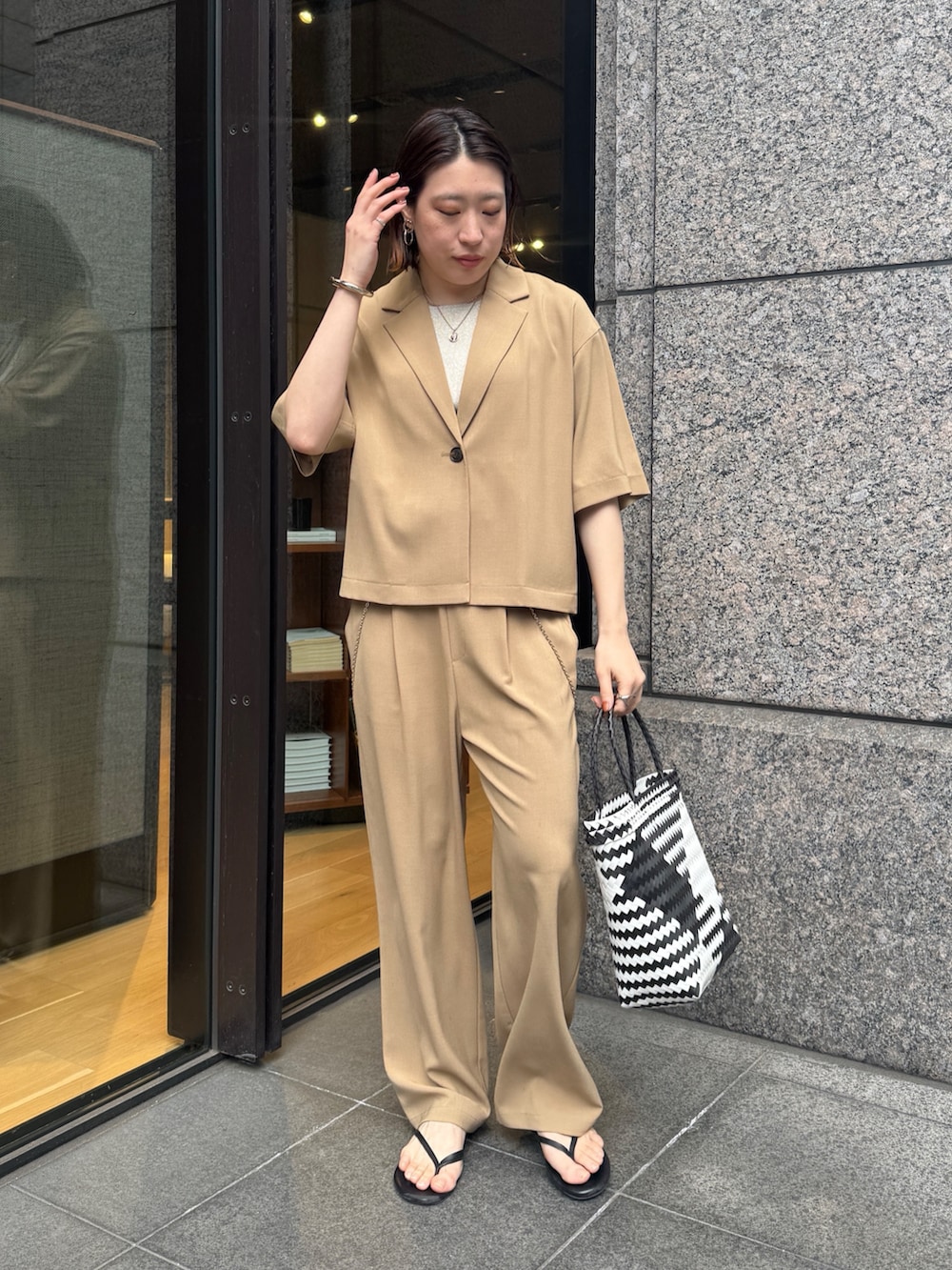 ベージュ系のニット/セーター、ベージュ系のその他パンツ、ベージュ系のテーラードジャケットを着用したレディースの春コーディネートの6枚目の写真