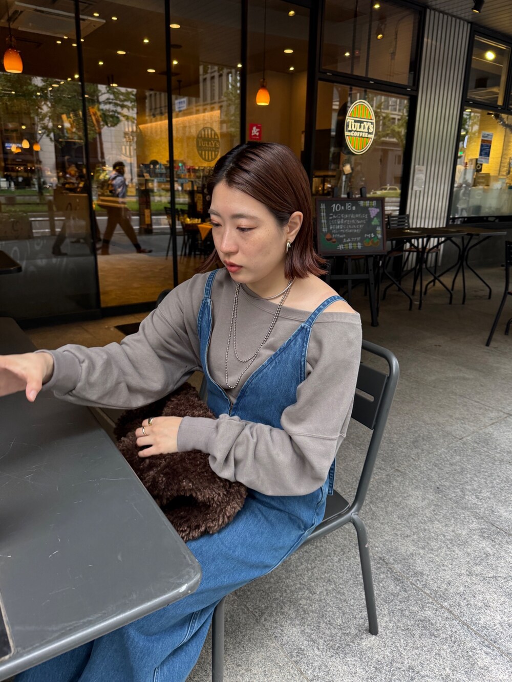 ブルー系のつなぎ/オールインワン、ベージュ系のスウェット、ブラウン系のショルダーバッグを着用したレディースの秋コーディネートの8枚目の写真