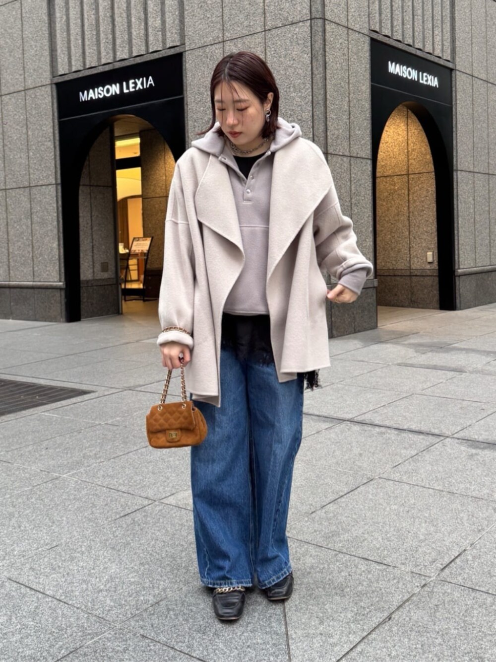 ベージュ系のその他アウター、ブルー系のデニムパンツ、グレー系のTシャツ/カットソーを着用したレディースの冬コーディネートの4枚目の写真