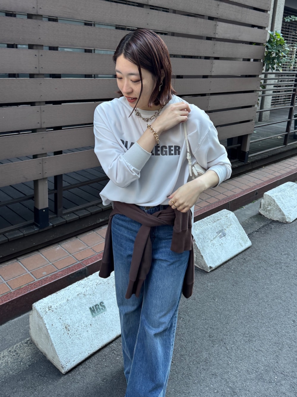 グレー系のシャツ/ブラウス、ブルー系のデニムパンツ、ブラウン系のスウェットを着用したレディースの冬コーディネートの2枚目の写真