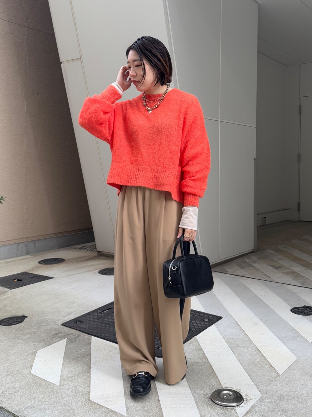 ベージュ系のその他パンツ、ホワイト系のその他アウター、オレンジ系のニット/セーターを着用したレディースの冬コーディネートの5枚目の写真