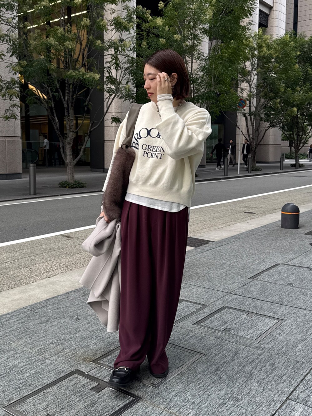 レッド系のスラックス、ベージュ系のその他アウター、ホワイト系のニット/セーターを着用したレディースの秋コーディネートの8枚目の写真