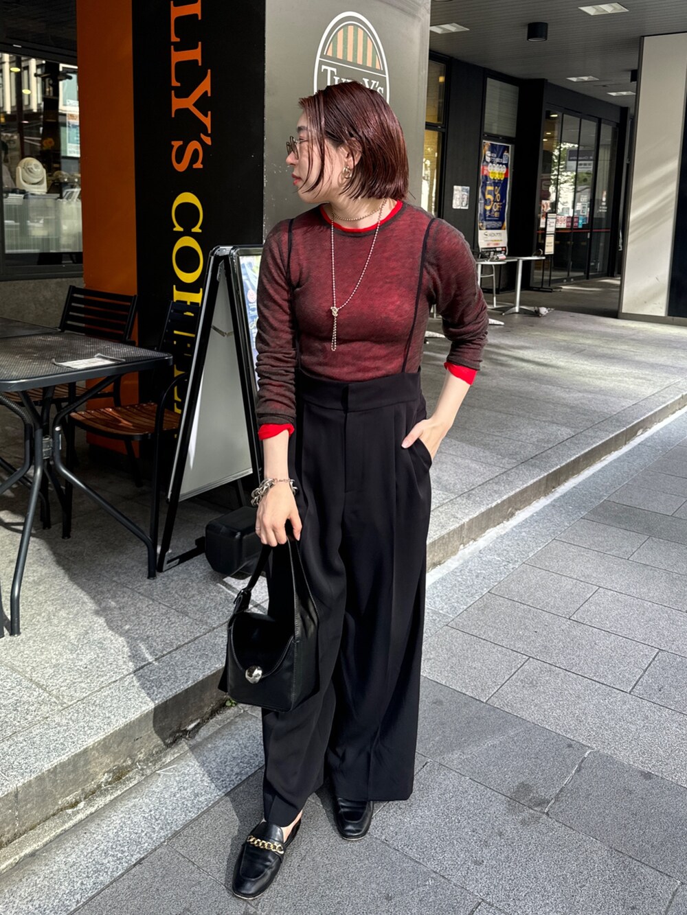 ブラック系のその他パンツ、グリーン系のその他アウター、レッド系のニット/セーターを着用したレディースの秋コーディネートの7枚目の写真